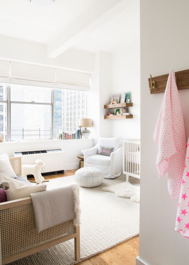 a living room with white furniture and a baby crib