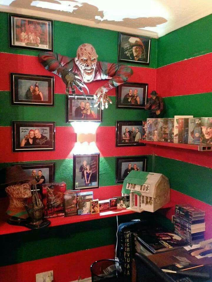 a room with red, green and white striped walls has pictures on the wall above it