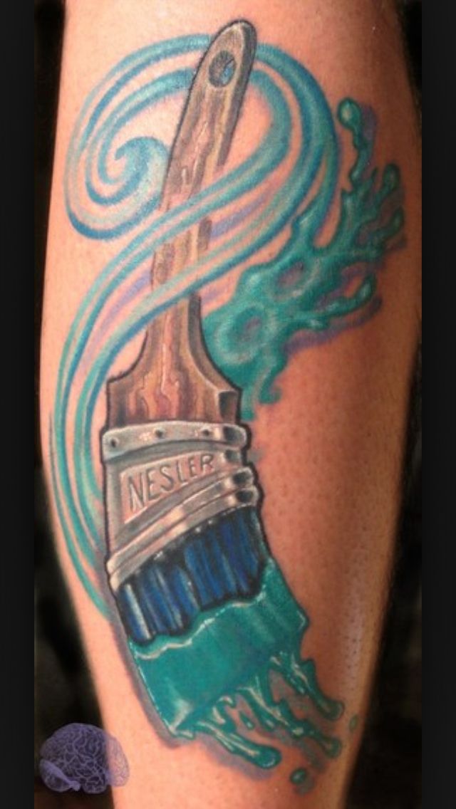 a close up of a person's leg with a tattoo on it and a brush