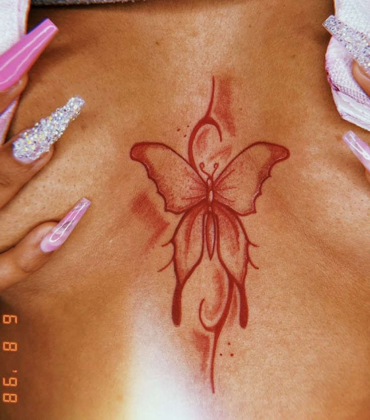 a close up of a woman's stomach with a butterfly tattoo on her back