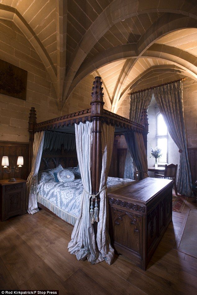 a large bed sitting in the middle of a bedroom next to a wooden table and chair