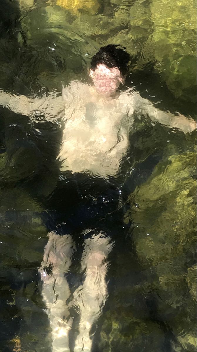 a man swimming in the water with his arms outstretched