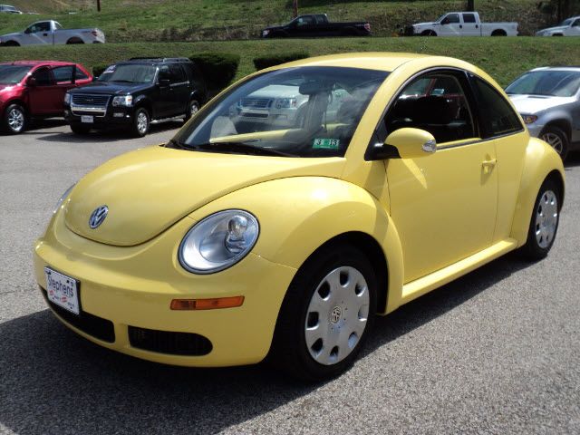 a yellow volkswagen beetle parked in a parking lot