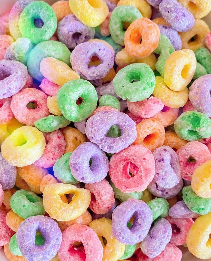 there is a bowl full of multicolored donuts with holes in the middle