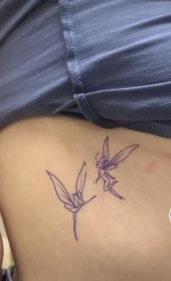 a woman with a tattoo on her stomach that has two hummings drawn on it