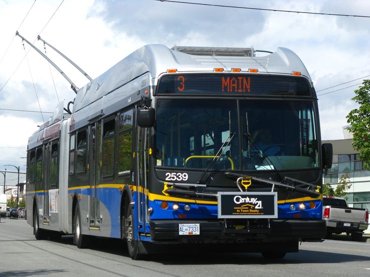 a city bus driving down the street in front of a building with power ...