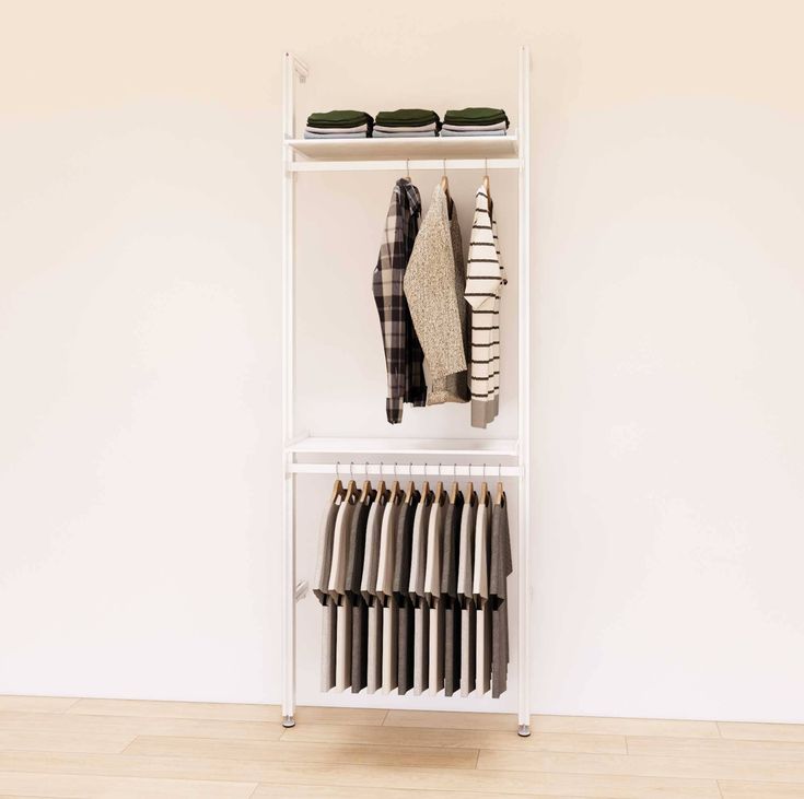 a white shelving unit with clothes on it