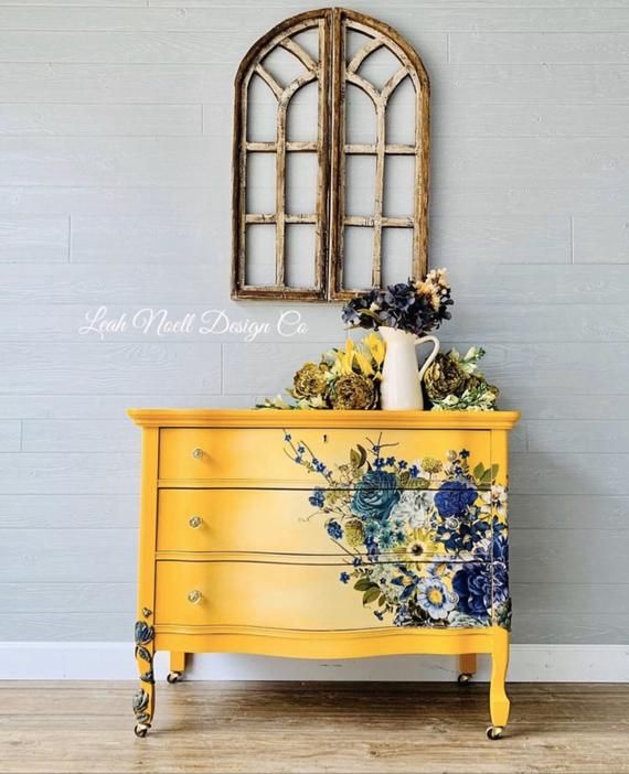 a yellow dresser with flowers painted on it