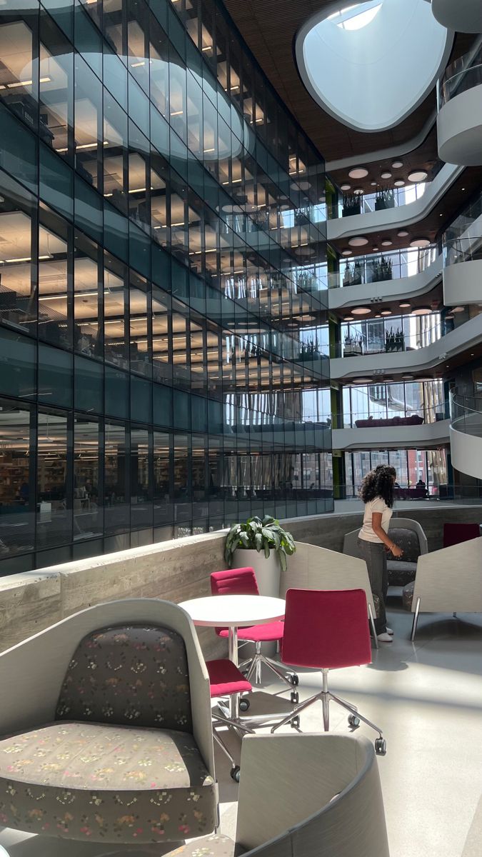 the interior of an office building with glass walls and circular seating area in front of large windows