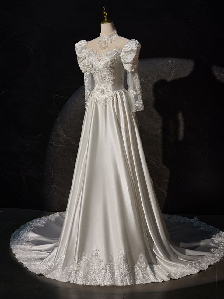 a white wedding dress on display in a dark room