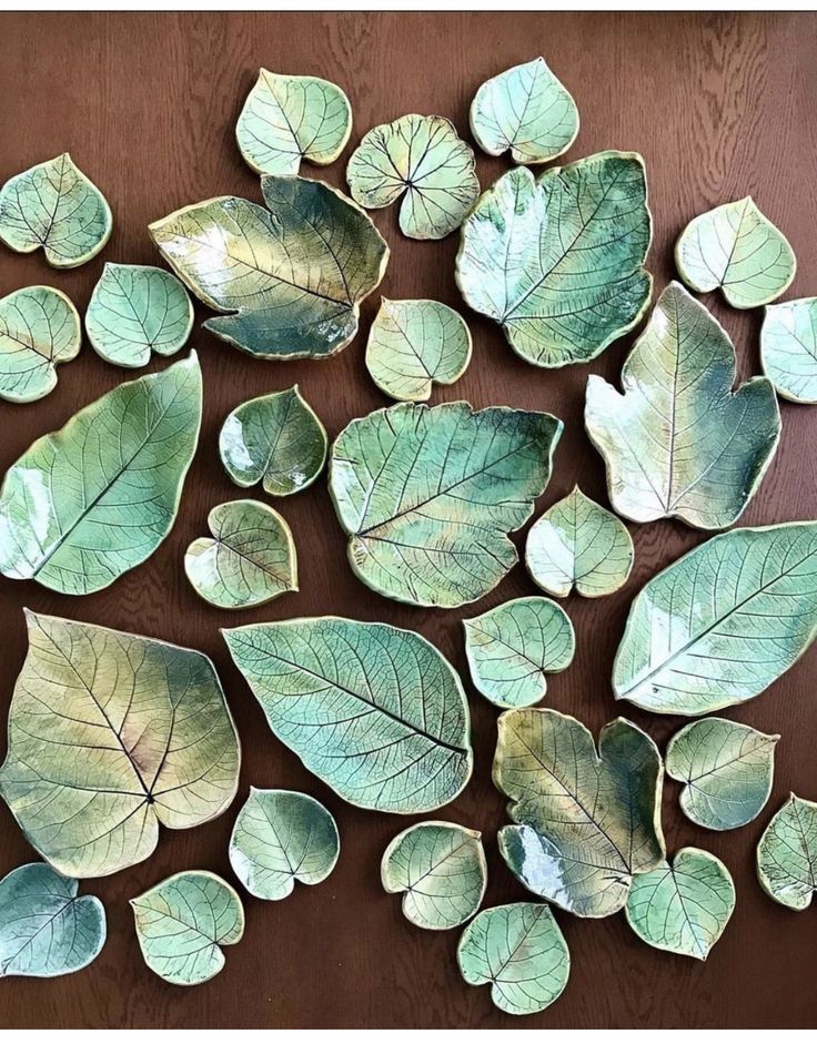 green leaf shaped dishes are arranged on a brown table top, with one being cut in half and the other is empty