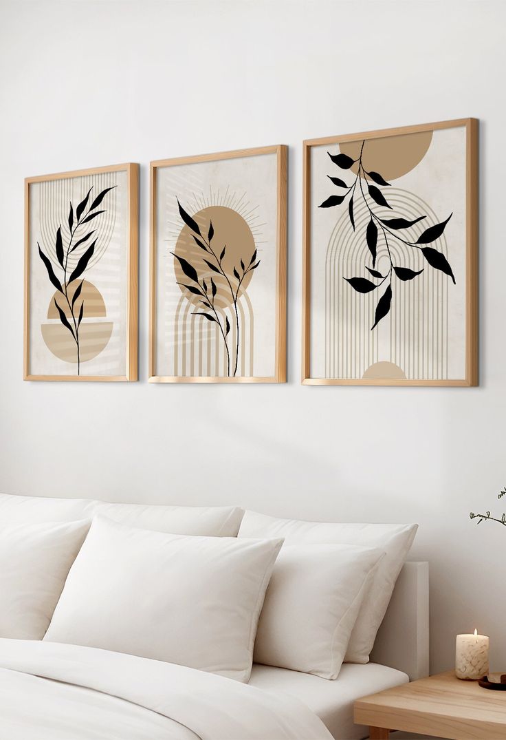 three framed pictures hang on the wall above a bed with white linens and pillows