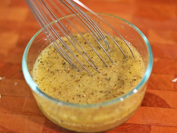 a glass bowl filled with yellow liquid and whisks