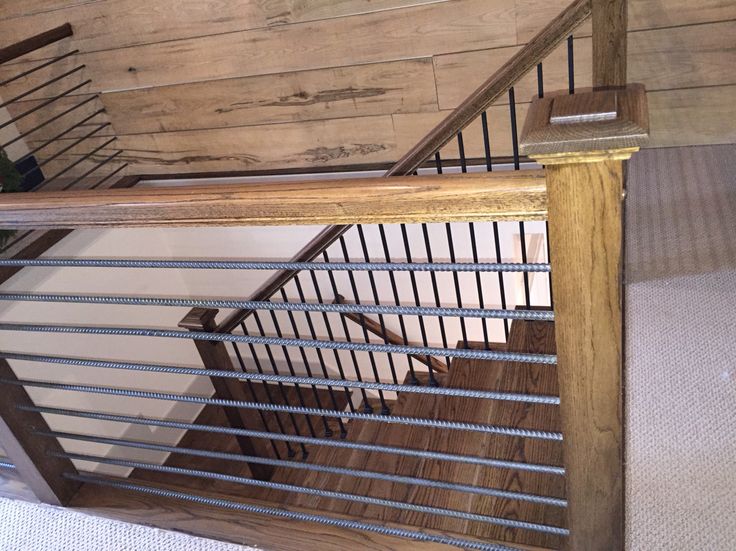 a wooden stair case with metal handrails