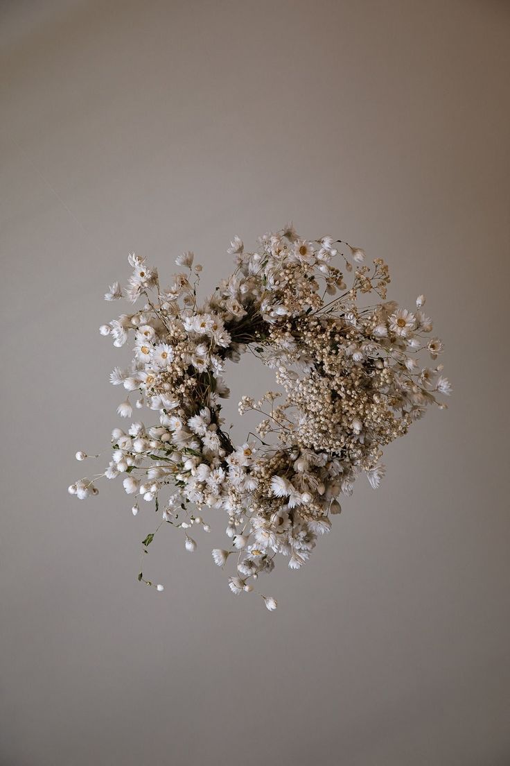 a bunch of white flowers hanging from the ceiling