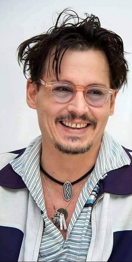 a close up of a person wearing glasses and a necklace with a mustache on it