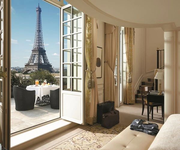 a living room filled with furniture and a large window overlooking the eiffel tower