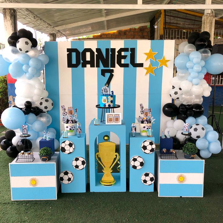 a table with balloons and decorations for a soccer themed party