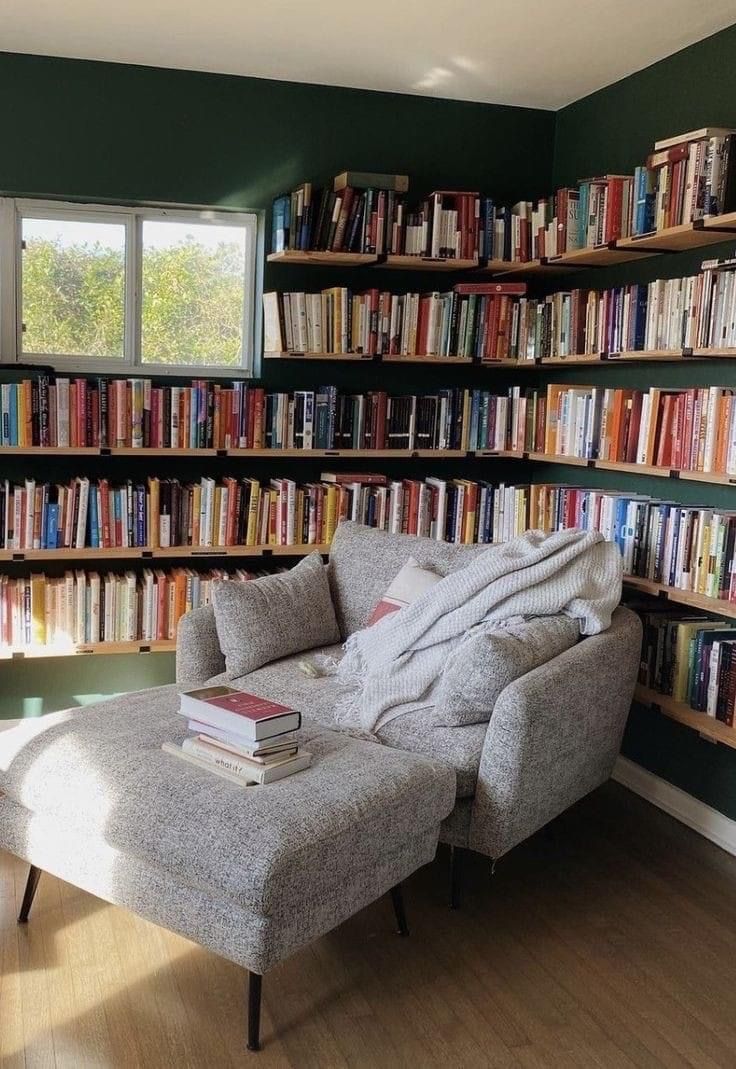 a chair and ottoman in front of a bookshelf with many books on it