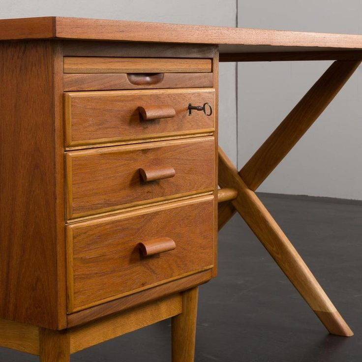 a wooden desk with three drawers and two handles on the top one is turned upside down