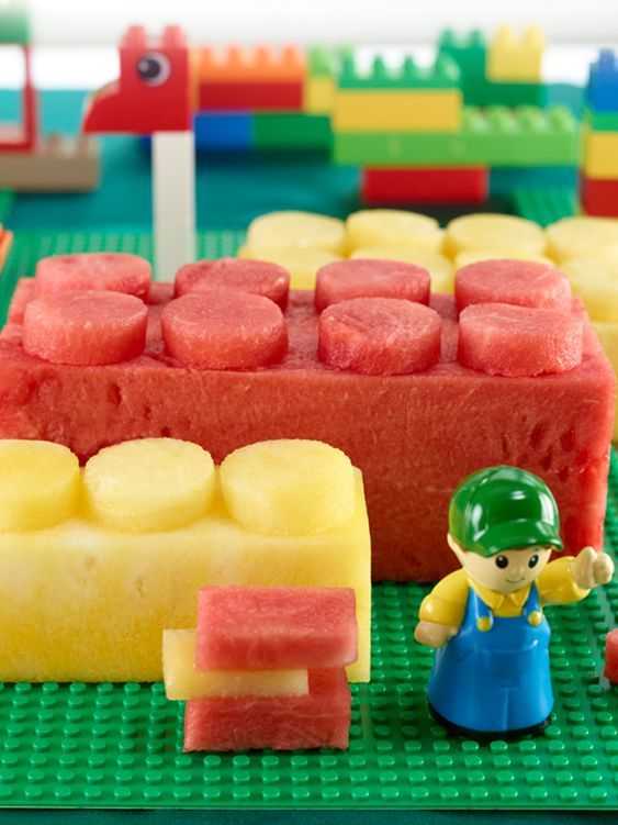 a lego set with watermelon, pineapple and banana slices on the table