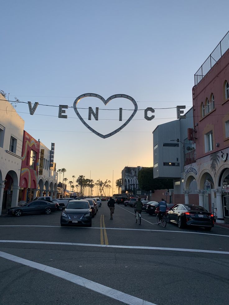 a city street with cars parked on both sides and a sign that says venice above it