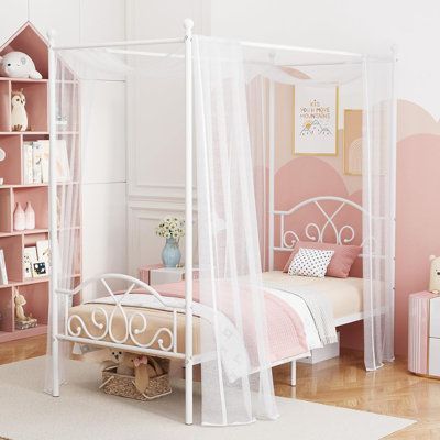 a white canopy bed sitting in a bedroom next to a book shelf filled with books