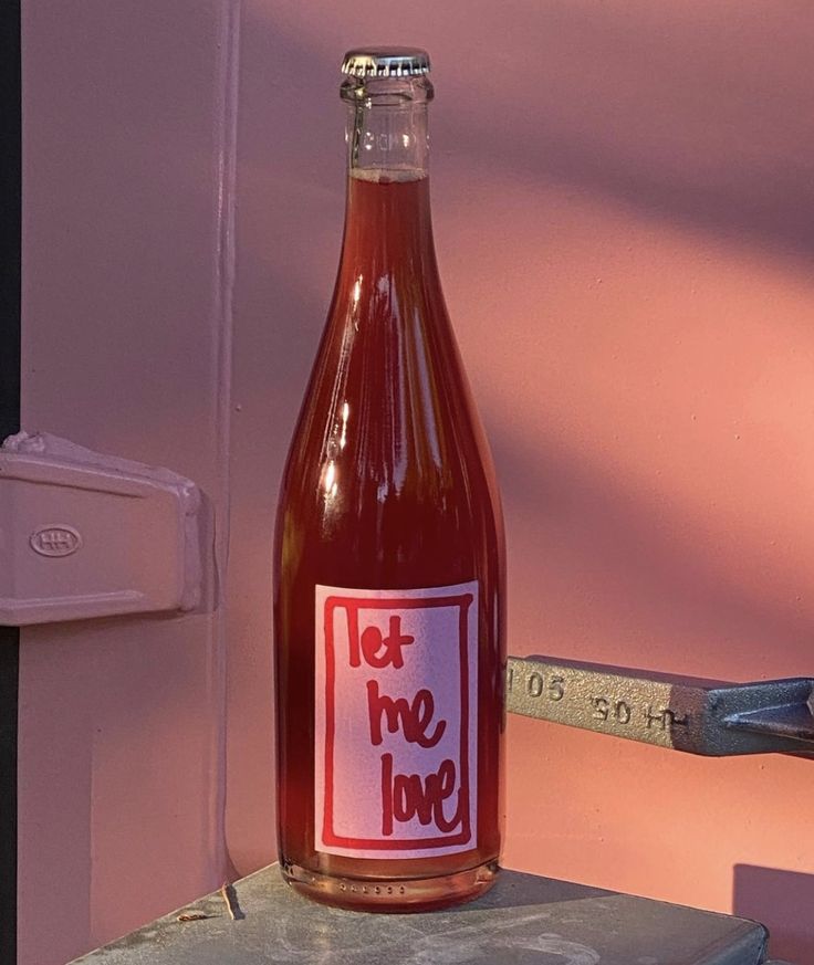 a bottle of ketchup sitting on top of a table next to a measuring tape