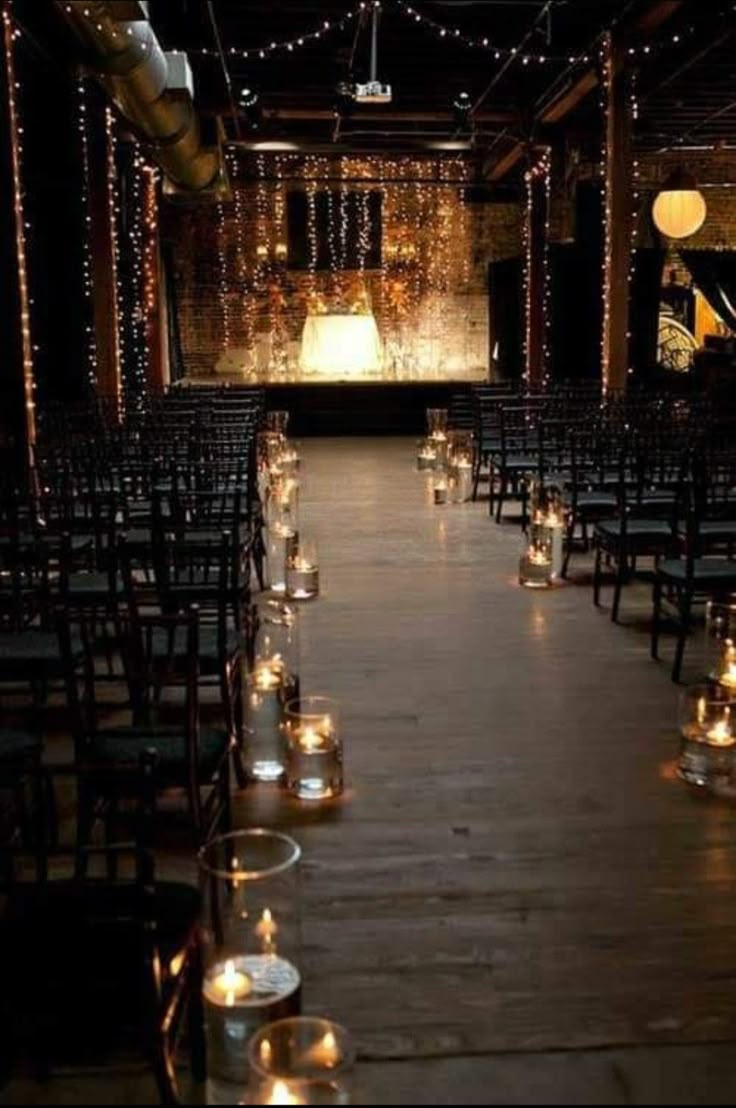 rows of chairs with lit candles in front of them