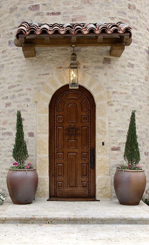 two large planters are sitting in front of the door to an old stone building