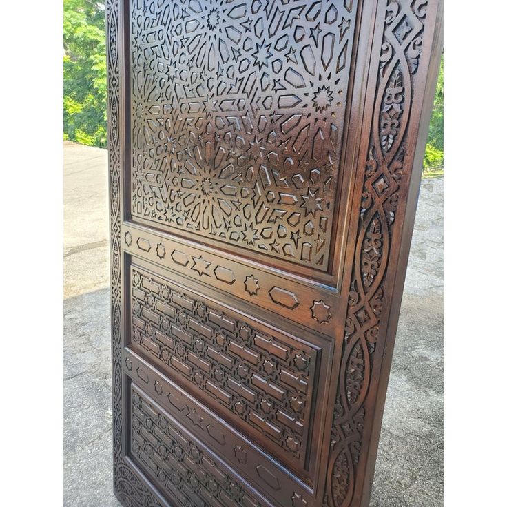 an intricately carved wooden door on the sidewalk