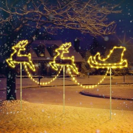 christmas lights on poles in the snow with santa's sleigh and reindeer