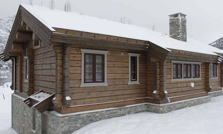 a log cabin with snow on the ground