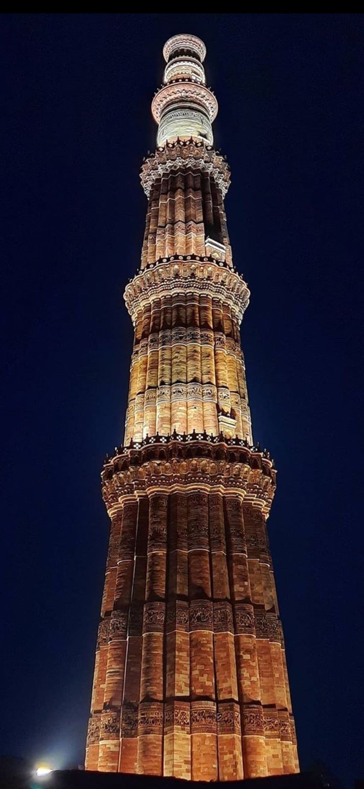 the tall tower is lit up at night