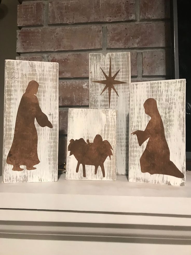 three wooden blocks with the silhouettes of jesus, mary and baby jesus on them