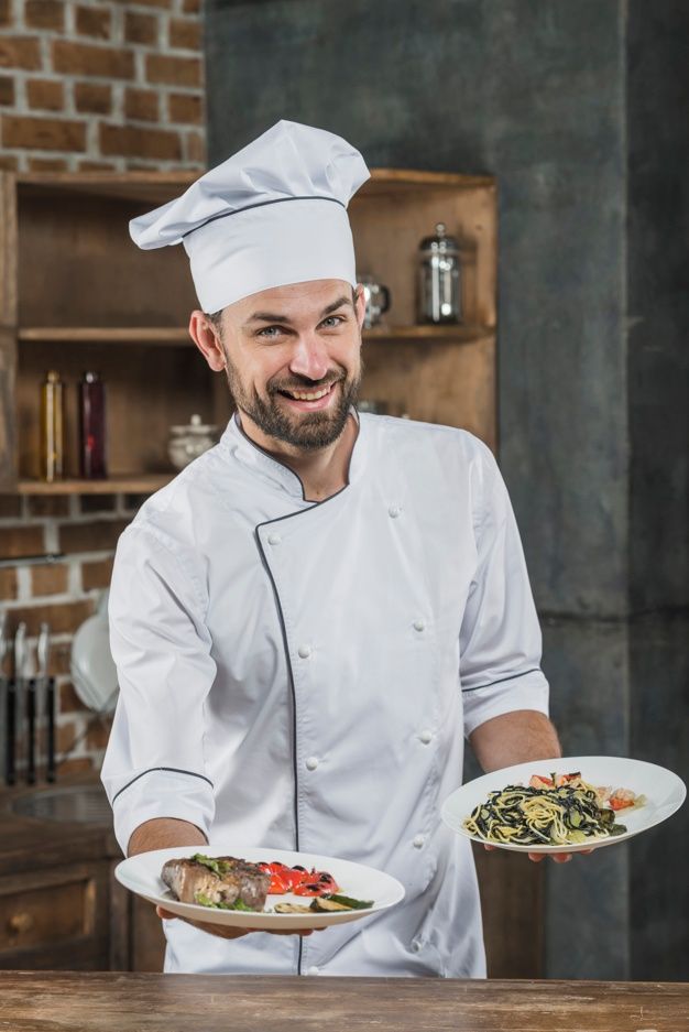 a man in a chef's outfit holding two plates with food on them and smiling