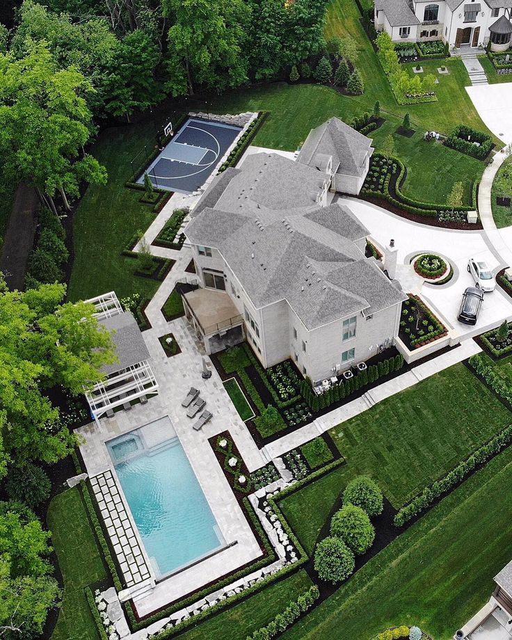 an aerial view of a large house with a pool and tennis court in the yard