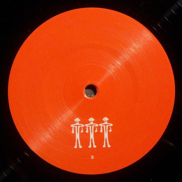 an orange vinyl record with white writing on the front and bottom side, featuring three people holding hands