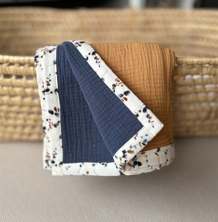 a cloth napkin is folded on top of a basket with a blue and brown fabric