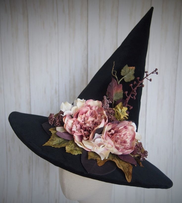 a witches hat with flowers and leaves on it