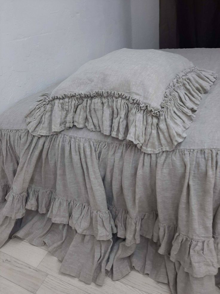 the bed is made up with ruffles on it's sides and bottom