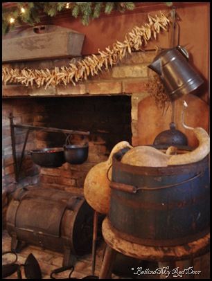 an old fashioned kitchen with pots and pans on the stove top next to a christmas tree