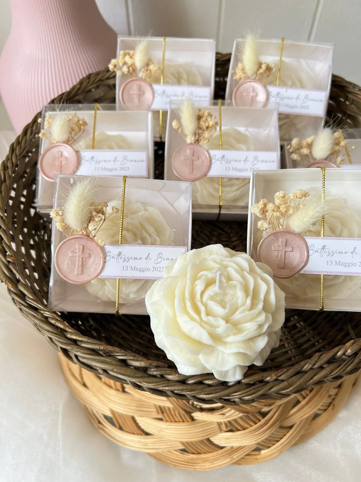 wedding favors in a wicker basket with white flowers and feathers on the table top