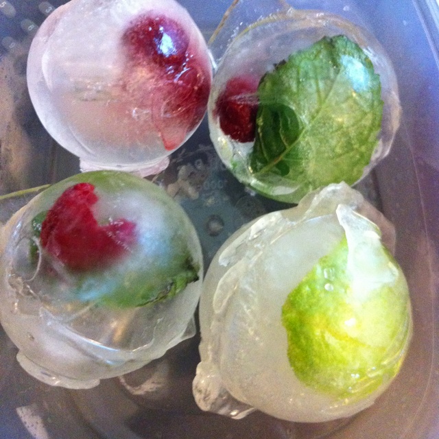 four frozen fruits are sitting on ice in a bowl