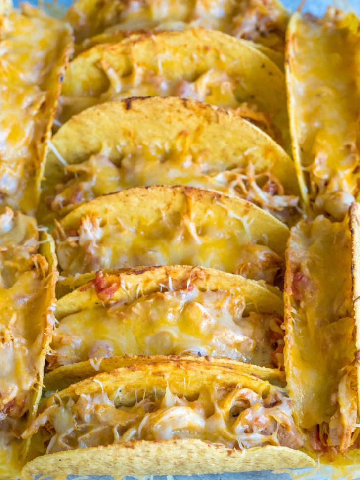 several tortilla shells in a baking dish with cheese and sauce on the top