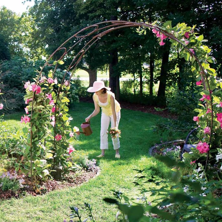 a woman walking through a lush green garden