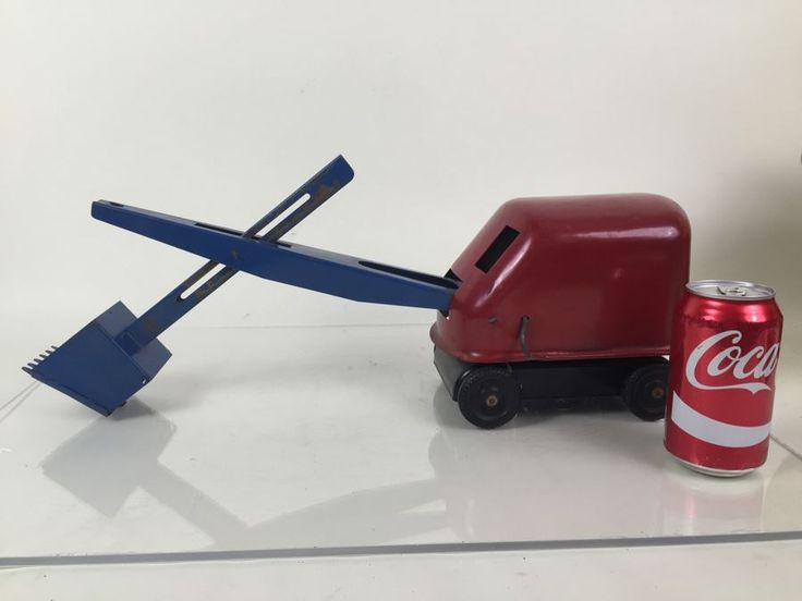 a small toy truck with a coca - cola can on it's back and an airplane shaped object in the background