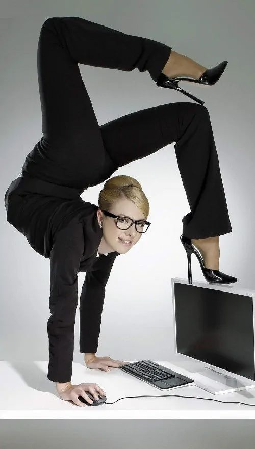 a woman is doing a handstand in front of a computer monitor and keyboard