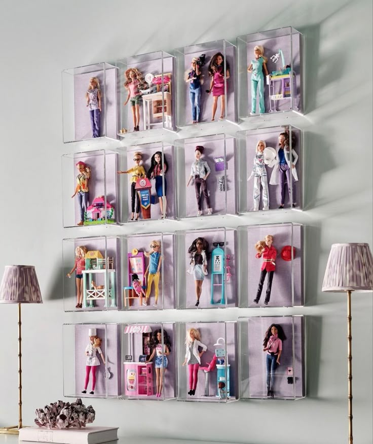 there are many barbie dolls on the wall