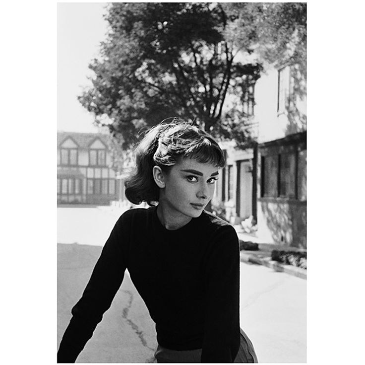 a black and white photo of a woman on a bike